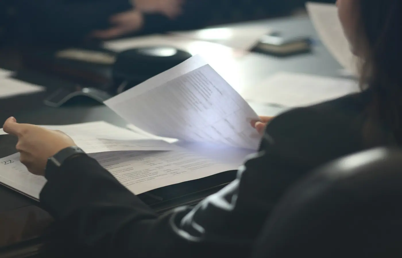 A supplier quality professional reviewing industrial qualification documents at a desk.